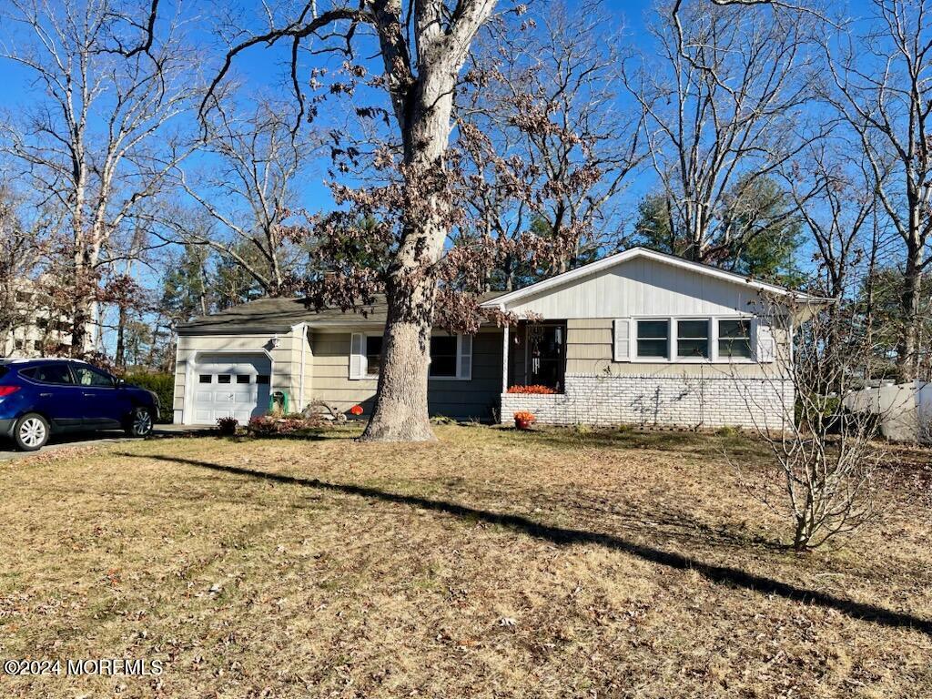 single story home with a front yard and a garage