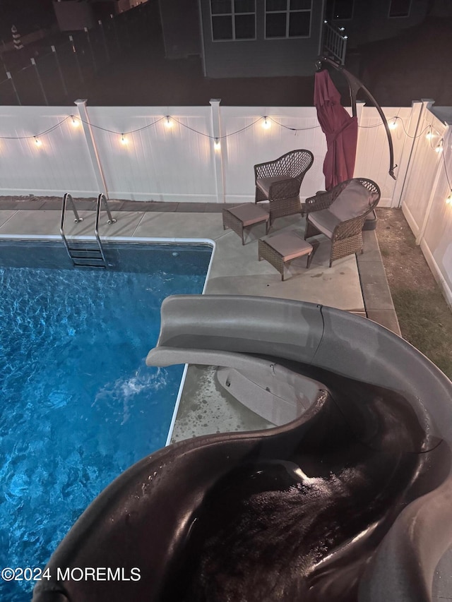 view of swimming pool featuring a hot tub and a water slide