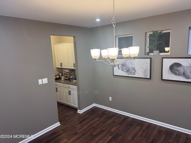 dining space with dark hardwood / wood-style flooring and a notable chandelier