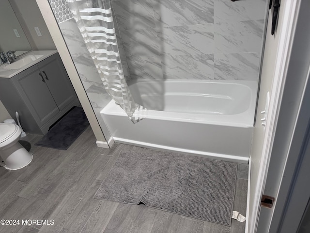 full bathroom featuring toilet, vanity, hardwood / wood-style floors, and shower / bath combination with curtain