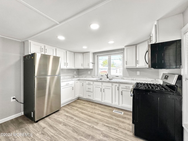 kitchen with stainless steel appliances, white cabinets, light hardwood / wood-style floors, and sink