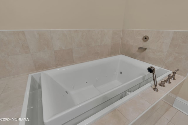 bathroom with tiled tub and tile patterned floors