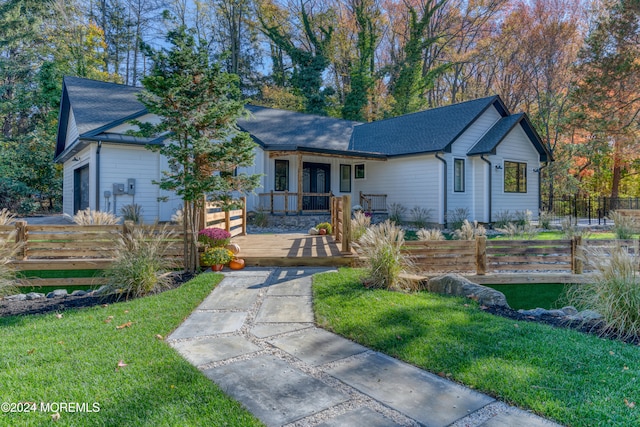 view of front of home with a front yard and a wooden deck