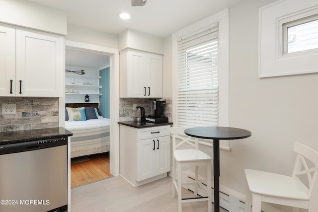 kitchen featuring decorative backsplash, white cabinetry, dishwasher, and a wealth of natural light