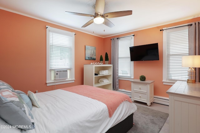 bedroom featuring baseboard heating, multiple windows, and ceiling fan