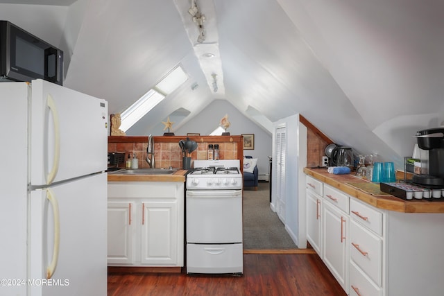 kitchen featuring dark hardwood / wood-style flooring, vaulted ceiling with skylight, white appliances, sink, and white cabinetry