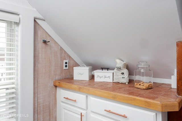 interior space with white cabinets and tile countertops