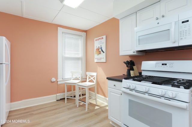 kitchen featuring baseboard heating, white cabinets, white appliances, and light wood-type flooring