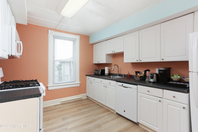 kitchen with sink, white cabinets, white appliances, and light wood-type flooring