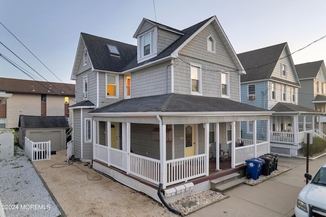 view of front of home with covered porch and a shed