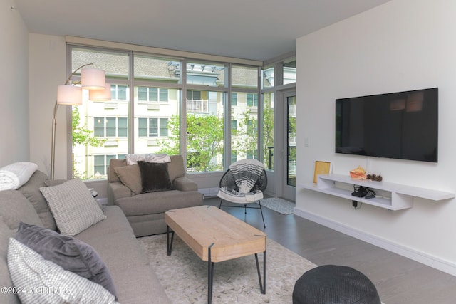 living room with dark wood-type flooring, a healthy amount of sunlight, and floor to ceiling windows