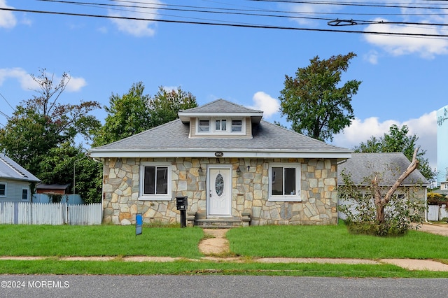 bungalow-style house with a front lawn