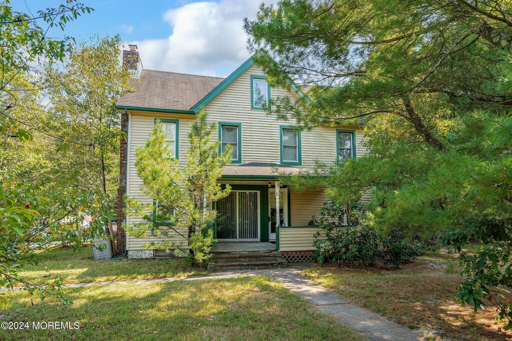 view of front of house featuring covered porch and a front yard