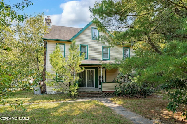 view of front of house featuring covered porch and a front yard