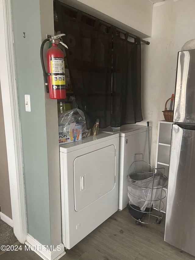 laundry room with wood-type flooring and washing machine and clothes dryer