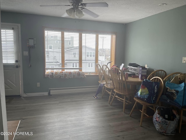 dining space featuring ceiling fan, hardwood / wood-style floors, a textured ceiling, and a baseboard radiator