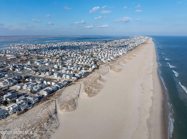 drone / aerial view with a water view and a beach view