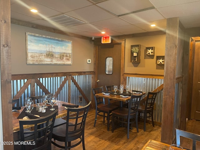 dining space with a drop ceiling and hardwood / wood-style flooring