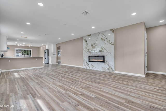 unfurnished living room with light wood-type flooring and a fireplace