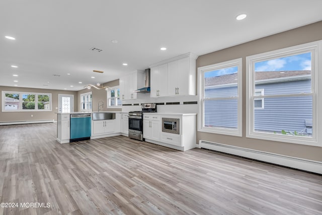 kitchen featuring sink, kitchen peninsula, wall chimney exhaust hood, stainless steel appliances, and light hardwood / wood-style floors