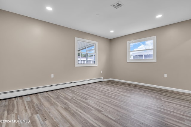 unfurnished room with light hardwood / wood-style floors and baseboard heating