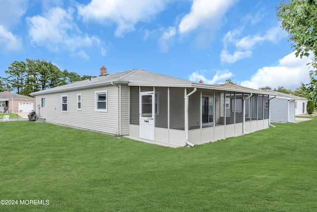 rear view of property featuring a lawn and a sunroom