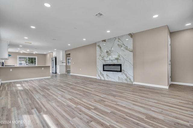 unfurnished living room with a fireplace and light hardwood / wood-style flooring