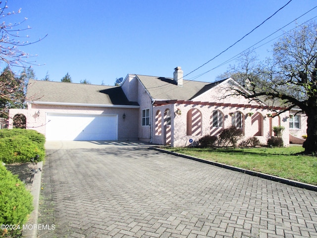 view of front of home with a garage and a front lawn