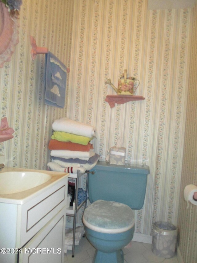 bathroom featuring tile patterned flooring, vanity, and toilet