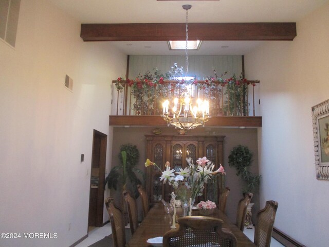 dining space with beamed ceiling and a chandelier