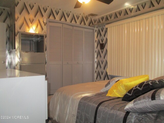 bedroom with ceiling fan and a closet