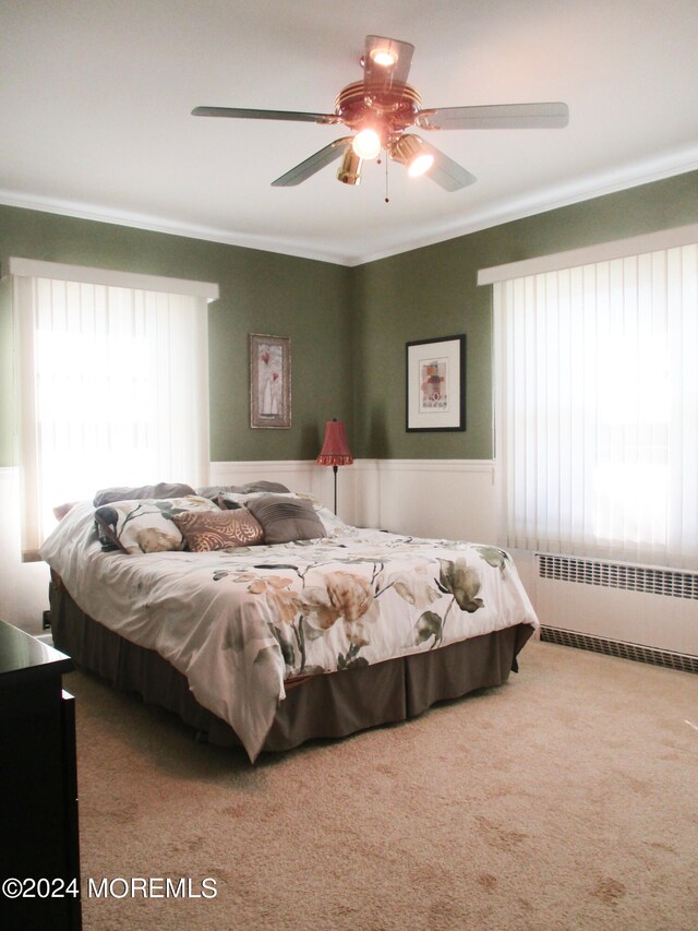 bedroom with ceiling fan, carpet floors, and radiator heating unit