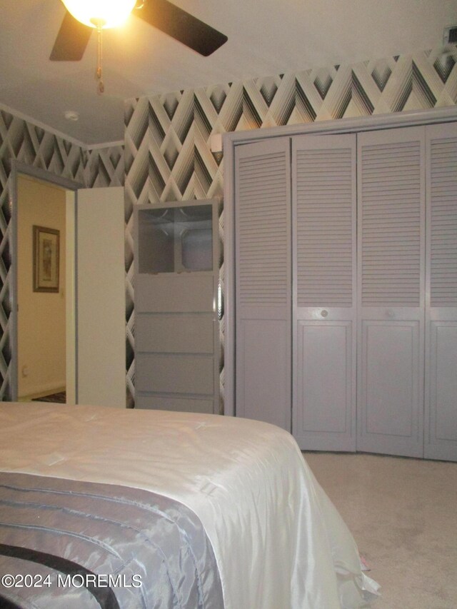 unfurnished bedroom featuring ceiling fan, a closet, and carpet