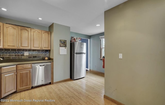 kitchen with baseboards, light brown cabinetry, decorative backsplash, light wood-style floors, and stainless steel appliances