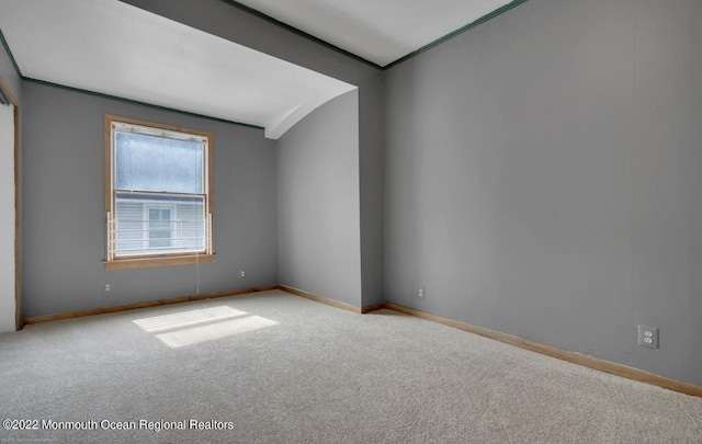 carpeted empty room featuring baseboards