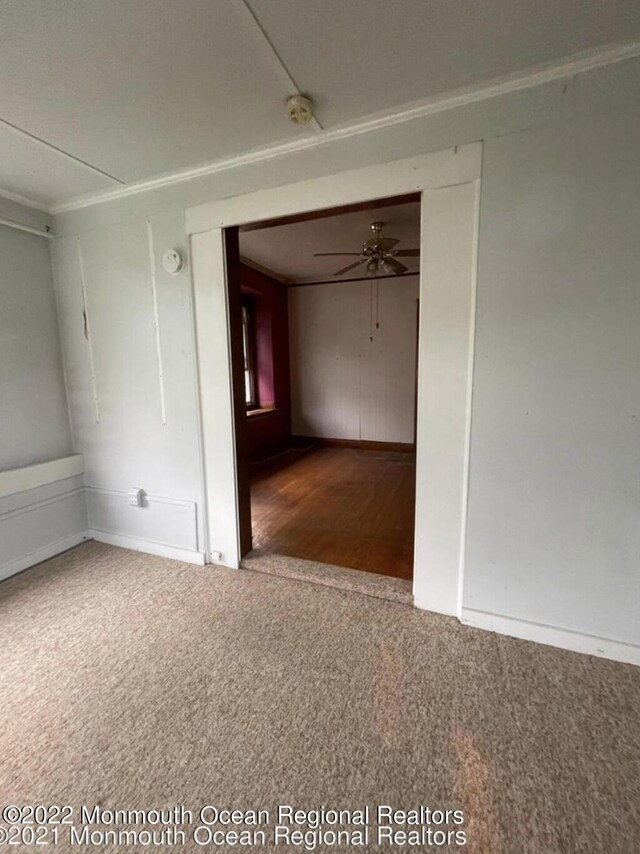 empty room featuring carpet flooring and ceiling fan