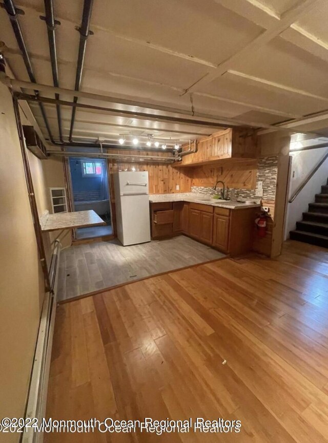 kitchen with white fridge, sink, and light hardwood / wood-style floors