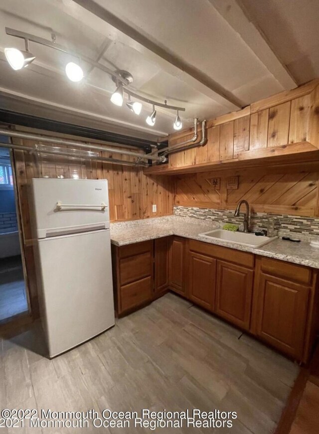 kitchen featuring white refrigerator, light stone counters, sink, and light hardwood / wood-style floors