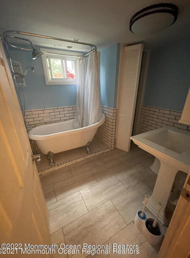 bathroom featuring tile patterned flooring, shower with separate bathtub, and tasteful backsplash