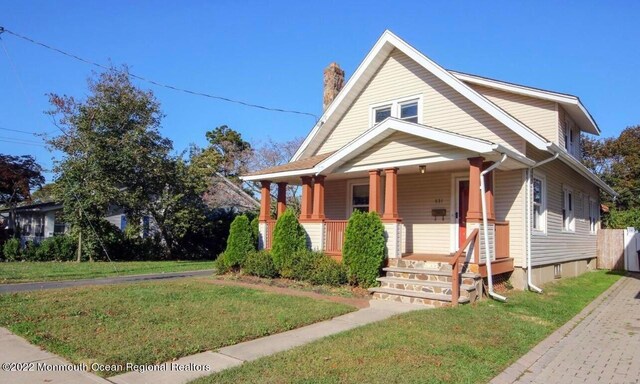 view of front of home with covered porch and a front yard