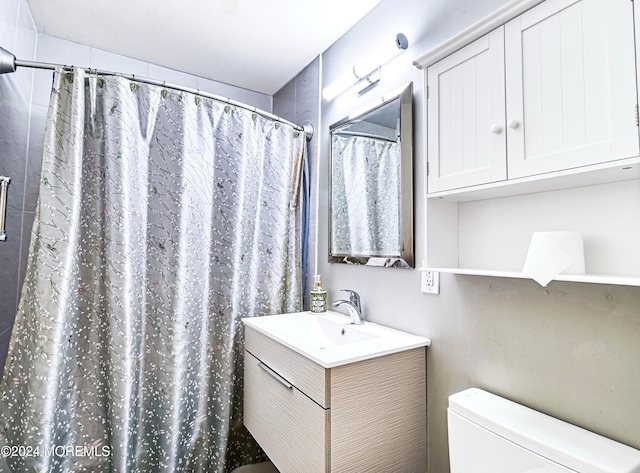 bathroom featuring vanity, toilet, and a shower with curtain