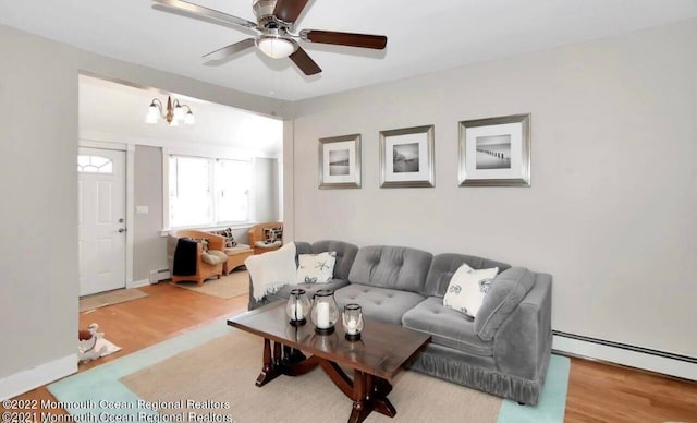 living room featuring ceiling fan, hardwood / wood-style floors, and a baseboard heating unit