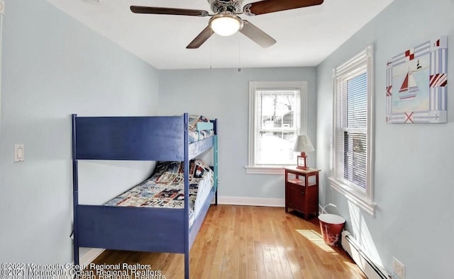 52 Liberty St, Long Branch, NJ 07740 - bedroom with a baseboard heating unit, wood finished floors, baseboards, and a ceiling fan