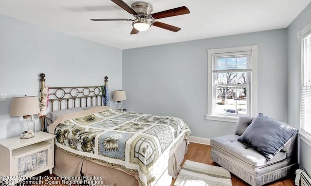 52 Liberty St, Long Branch, NJ 07740 - bedroom featuring a baseboard heating unit, wood finished floors, multiple windows, and baseboards