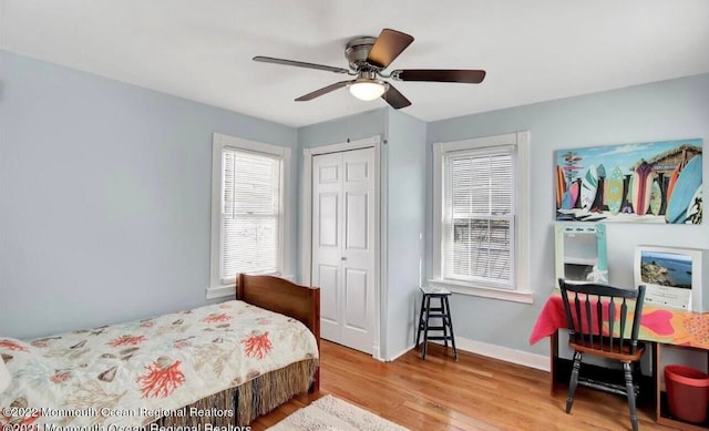 bedroom with ceiling fan, a closet, and wood-type flooring