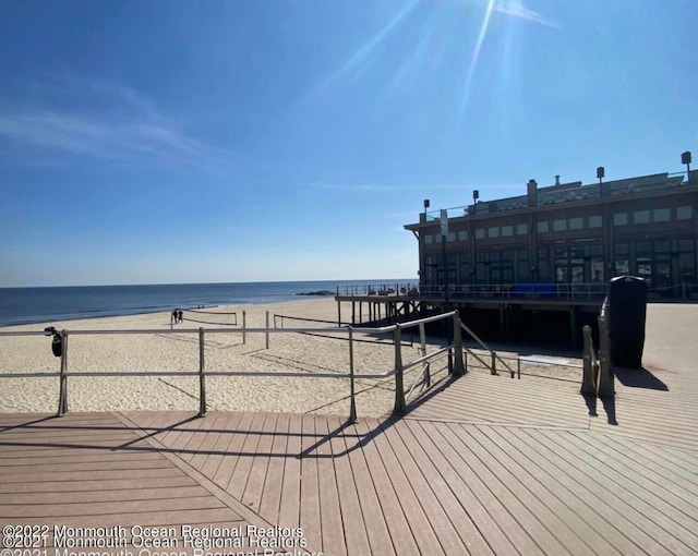 deck featuring a view of the beach and a water view