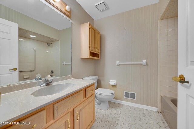 full bathroom featuring tiled shower / bath combo, vanity, and toilet