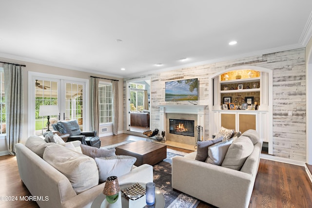 living room featuring built in features, french doors, ornamental molding, and dark hardwood / wood-style floors