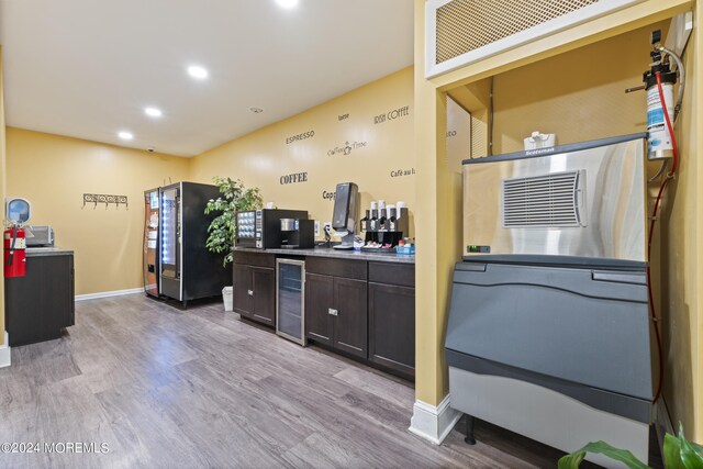 interior space featuring light hardwood / wood-style flooring, dark brown cabinets, stainless steel fridge, and beverage cooler