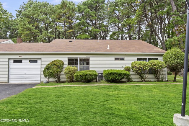 view of front of property featuring a garage and a front lawn